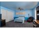 Large bedroom with blue walls, ceiling fan and an adjacent desk and shelving at 8213 Cabin Springs Ave, Las Vegas, NV 89131