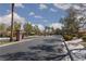 View of a street scene with mature trees, sidewalks, and community entrance gates at 8213 Cabin Springs Ave, Las Vegas, NV 89131