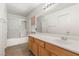 Bathroom featuring a large mirror over the vanity and a shower-tub combo at 89 Day Trade St # 1, Henderson, NV 89074