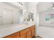 Bright bathroom featuring a double sink vanity and a large mirror plus access to the bedroom at 89 Day Trade St # 1, Henderson, NV 89074