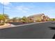 View of the community entrance with manicured landscaping, secure gates, and well-maintained townhomes in the background at 89 Day Trade St # 1, Henderson, NV 89074