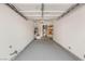 A spacious two car garage with a painted floor, shelving and water heater at 89 Day Trade St # 1, Henderson, NV 89074