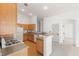 Bright kitchen featuring wood cabinets, stone countertops, white appliances, and an open layout with breakfast bar at 89 Day Trade St # 1, Henderson, NV 89074