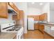 A functional kitchen layout with wood cabinets, white appliances, and ample counter space at 89 Day Trade St # 1, Henderson, NV 89074