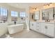 Bright bathroom featuring a freestanding tub under large windows and double vanity, creating a spa-like atmosphere at 9722 Rocket Grove Ct, Las Vegas, NV 89178