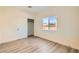 Simple bedroom with wood-look flooring, sliding-door closet, and window with view of surrounding neighborhood at 9722 Rocket Grove Ct, Las Vegas, NV 89178
