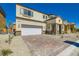 Attractive two-story house with a two-car garage, stone accents, and a brick driveway, surrounded by desert landscaping at 9722 Rocket Grove Ct, Las Vegas, NV 89178