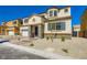 Inviting two-story home with a textured facade, stone accents, blue shutters, and desert-style landscaping under a clear blue sky at 9722 Rocket Grove Ct, Las Vegas, NV 89178