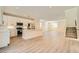 Modern kitchen with white cabinets, stainless steel appliances, an island, and wood-style floors, open to the living area at 9722 Rocket Grove Ct, Las Vegas, NV 89178