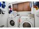 Bright laundry room equipped with a washer, dryer, storage cabinets, and hat rack at 9864 Maspalomas St, Las Vegas, NV 89178