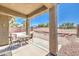 Relaxing covered patio with charming wicker furniture and views of the landscaped backyard at , Las Vegas, NV 89122