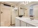 Bathroom featuring a shower with sliding glass door, white cabinets and a large vanity mirror at 1038 Silver Creek Ave, Las Vegas, NV 89183