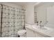 Updated bathroom with a toilet, patterned shower curtain, and a sink with white cabinets at 1038 Silver Creek Ave, Las Vegas, NV 89183