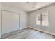 Bedroom featuring a window with black trim, laminate floors, and a closet with sliding doors at 1038 Silver Creek Ave, Las Vegas, NV 89183