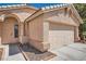 Charming single-story home with a two-car garage, desert landscaping, and an arched entryway at 1038 Silver Creek Ave, Las Vegas, NV 89183
