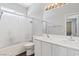 Bright bathroom featuring double sinks, a shower over bath, and modern fixtures at 10918 Avenzano St, Las Vegas, NV 89141