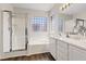 Bright bathroom featuring a double vanity, tub, and separate shower with tile surround at 10918 Avenzano St, Las Vegas, NV 89141