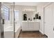 Bright bathroom features a double vanity, soaking tub and shower with decorative window at 10918 Avenzano St, Las Vegas, NV 89141