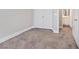 Minimalist bedroom showing neutral carpet, baseboards, and doorway to the bathroom at 10918 Avenzano St, Las Vegas, NV 89141
