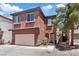Two-story home with a terracotta stucco exterior, two-car garage, and a small balcony at 10918 Avenzano St, Las Vegas, NV 89141