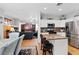Bright kitchen with white cabinets, stainless appliances, tile backsplash, and an island with bar seating at 10918 Avenzano St, Las Vegas, NV 89141