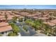 Expansive view of a neighborhood entrance with mature trees along with tile rooftops and landscaping at 10918 Avenzano St, Las Vegas, NV 89141