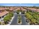 Wide angle shot showcasing neighborhood entrance and tile rooftops with lush landscaping at 10918 Avenzano St, Las Vegas, NV 89141