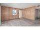 Living room featuring wood paneling, carpet flooring, a window, and white door at 1108 Princess Katy Ave, Las Vegas, NV 89119
