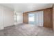 Living room featuring wood paneling and carpet flooring with a sliding glass door to the backyard at 1108 Princess Katy Ave, Las Vegas, NV 89119