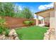 Inviting backyard with artificial turf, a brick wall, and a covered patio at 11139 Zarod Rd, Las Vegas, NV 89135