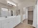 Bathroom with double sinks, tub shower combo, and mirrored closet doors at 11139 Zarod Rd, Las Vegas, NV 89135