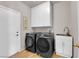 Functional laundry room with modern washer and dryer, sink, and storage cabinets at 11139 Zarod Rd, Las Vegas, NV 89135