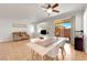 Open-concept living and dining area with tile flooring, ceiling fan, and sliding door to the backyard at 11139 Zarod Rd, Las Vegas, NV 89135