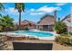 Backyard oasis with a pristine swimming pool, surrounded by lush greenery, palm trees, and ample seating at 124 Wynntry Dr, Henderson, NV 89074