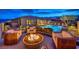 Lush backyard has fire pit surrounded by outdoor sofa, desert landscaping, and an inviting pool that offers beautiful views at 12544 Claymore Highland Ave, Las Vegas, NV 89138