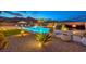 Tranquil backyard features a luxury pool, beautiful landscaping, mountain views, and lounge seating around a modern gas fire pit at 12544 Claymore Highland Ave, Las Vegas, NV 89138