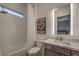This bathroom features a shower, toilet, vanity with an illuminated mirror, and a Las Vegas themed decoration at 12544 Claymore Highland Ave, Las Vegas, NV 89138