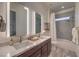 This bathroom has double vanity, a shower-tub with tile surround, and framed mirrors at 12544 Claymore Highland Ave, Las Vegas, NV 89138