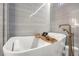 Close up of a freestanding white bathtub with gold hardware and accessories in a luxurious bathroom at 12544 Claymore Highland Ave, Las Vegas, NV 89138