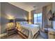 This is a primary bedroom showcasing stylish decor and a large window for natural light at 12544 Claymore Highland Ave, Las Vegas, NV 89138