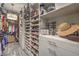 An organized walk-in closet with custom shelving for shoes, clothes, handbags, and other accessories at 12544 Claymore Highland Ave, Las Vegas, NV 89138