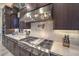 Close-up of modern kitchen appliances, including a stainless steel range hood and cooktop at 12544 Claymore Highland Ave, Las Vegas, NV 89138