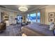 A bright and spacious main bedroom featuring a king bed, sitting area, mountain views, and access to an ensuite bathroom at 12544 Claymore Highland Ave, Las Vegas, NV 89138