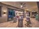 Expansive covered patio features travertine flooring, ceiling fan, and access to home interior through large sliding glass doors at 12544 Claymore Highland Ave, Las Vegas, NV 89138