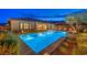 Backyard with pool has built in spa, desert landscaping, and an outdoor eating area, all lit for night time enjoyment at 12544 Claymore Highland Ave, Las Vegas, NV 89138
