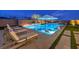 Inviting pool and spa feature built in lounge chairs, umbrella, outdoor fireplace, and elegant landscaping for evening enjoyment at 12544 Claymore Highland Ave, Las Vegas, NV 89138