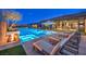 Inviting pool and spa area features built in lounge chairs, an umbrella, and outdoor fireplace surrounded by lounge seating at 12544 Claymore Highland Ave, Las Vegas, NV 89138