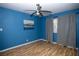Well-lit bedroom with wood-look floors, blue walls, ceiling fan and window at 1340 Lucky St, Las Vegas, NV 89104