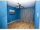 Bedroom with wood-look floors, bright blue walls, and modern ceiling fan at 1340 Lucky St, Las Vegas, NV 89104