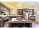 Kitchen with an island, stainless steel appliances, dark cabinets, and tiled floor at 159 Coastal Pier Ct, Henderson, NV 89002